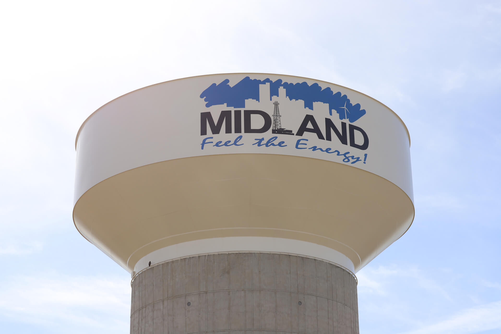 Water tower in Midland, TX with the words "Midland Feel the Energy!" painted on the side, symbolizing the city's vibrancy and energy sector heritage.